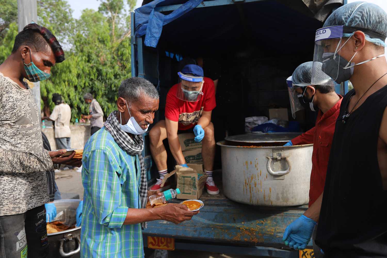 Daily wage laborers and homeless people wait in a queue to receive free food during a lockdown imposed to curb the spread of the coronavirus disease in New Delhi. (Photo by Amarjeet Kumar Singh / SOPA Images/Sipa USA)No Use Germany.