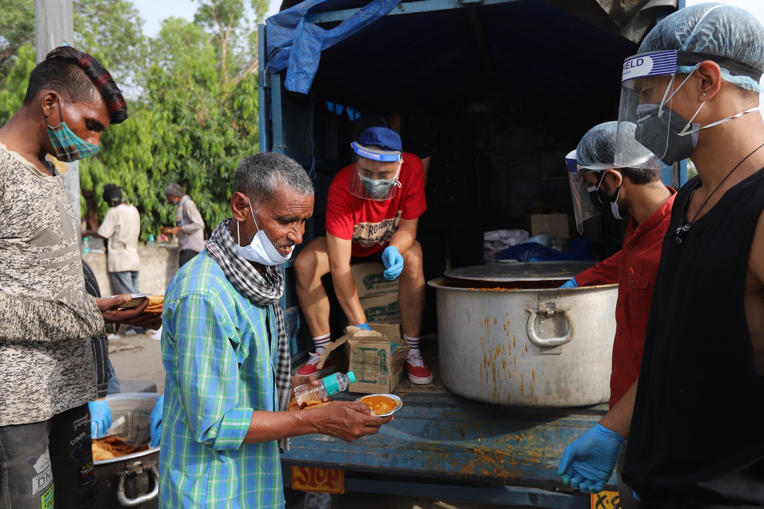 Daily wage laborers and homeless people wait in a queue to receive free food during a lockdown imposed to curb the spread of the coronavirus disease in New Delhi. (Photo by Amarjeet Kumar Singh / SOPA Images/Sipa USA)No Use Germany.