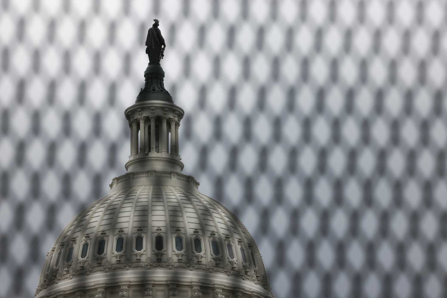 The U.S. Capitol building is seen through fencing set up after the Jan. 6 assault on the building.