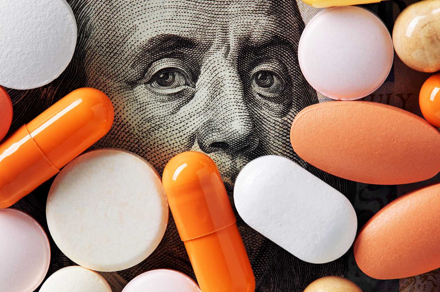 One hundred dollar bill underneath a pile of pills.