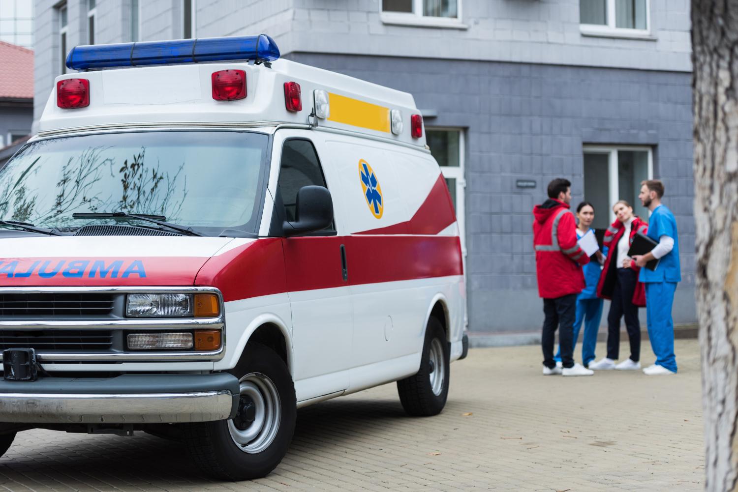 Group of people talking next to an ambulance