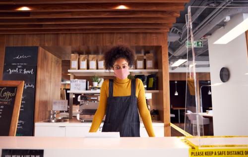 Woman behind a counter wearing a mask