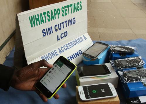 A street vendor adjusts the internet settings on a customer's mobile phone in Harare, Zimbabwe, January 13, 2017. REUTERS/Philimon Bulawayo