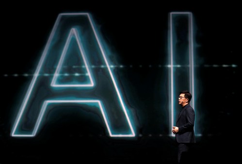 Man stands on stage with AI in background