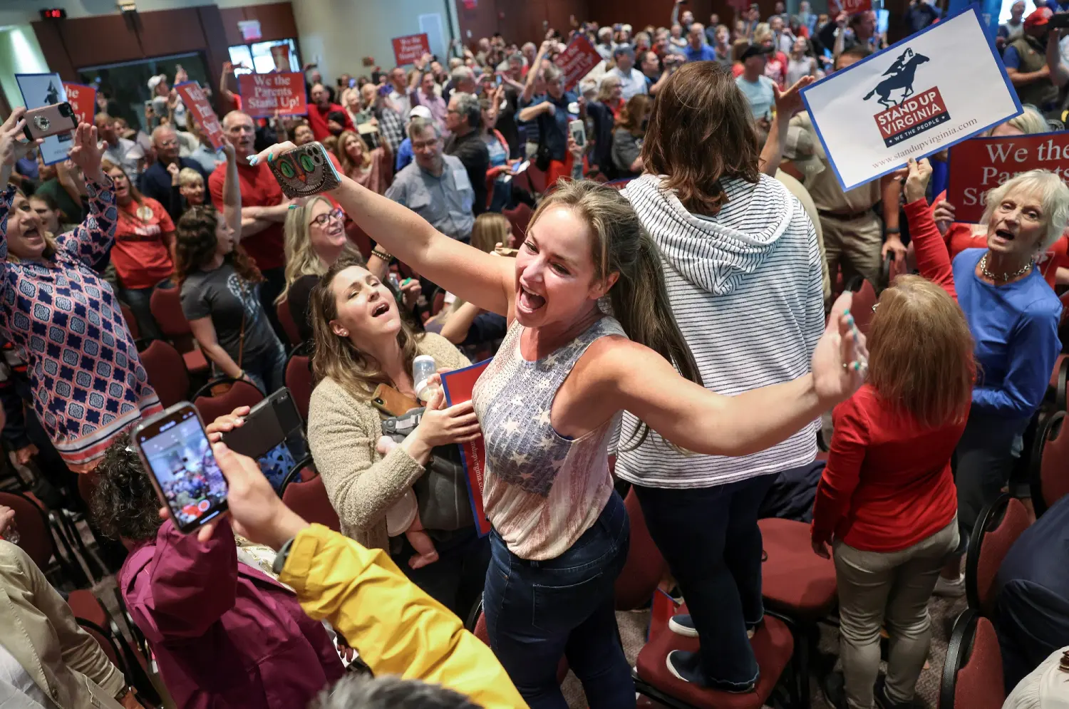 Elicia Brand leads a crowd of angry parents and community members in the singing of the Star Spangled Banner after a Loudoun County School Board meeting was halted by the school board because the crowd refused to quiet down, in Ashburn, Virginia, U.S. June 22, 2021. REUTERS/Evelyn Hockstein