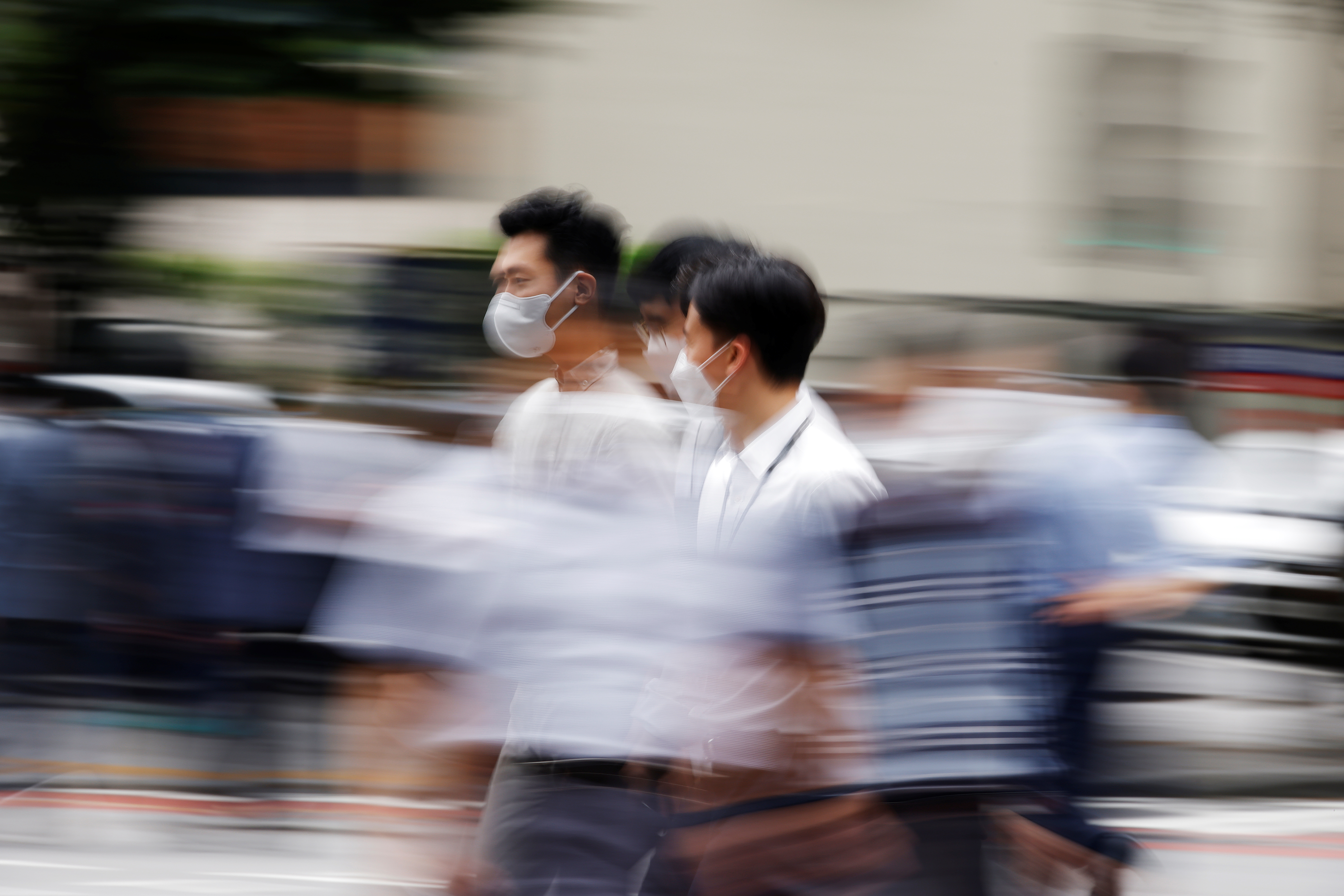 Men wearing masks to avoid contracting the coronavirus disease (COVID-19) walk on a zebra crossing in Seoul, South Korea, July 5, 2021. REUTERS/Kim Hong-Ji