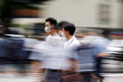 Men wearing masks cross a street in Seoul, South Korea.