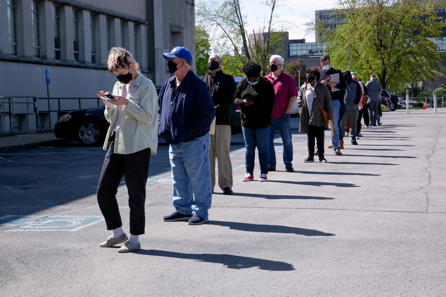 FILE PHOTO: People line up outside a newly reopened career center for in-person appointments in Louisville, U.S., April 15, 2021. REUTERS/Amira Karaoud/File Photo