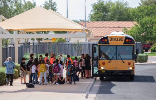 Students board a school bus after finishing their first day at Sanborn Elementary School in Chandler on July 21. Chandler is the first Arizona district to return to school.Sanborn Elementary School