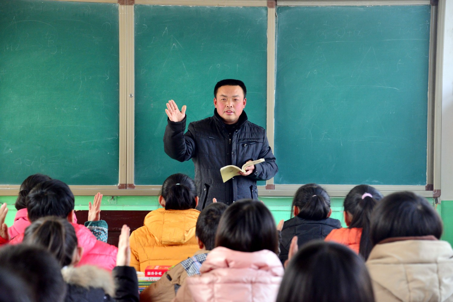 --FILE--A male Chinese teacher gives a lesson to his students in a classroom at a junior high school in Shiziyuan town, Shenxian county, Liaocheng city, east China's Shandong province, 13 January 2015.Worried that a shortage of male teachers has produced a generation of timid, self-centred and effeminate boys, educators in China are working to reinforce traditional gender roles and values in the classroom. In Zhengzhou, a city on the southern bank of the Yellow River, schools have asked boys to sign petitions pledging to act like "real men". In Shanghai, principals are trying boys-only classes, with courses like martial arts, computer repair and physics. In Hangzhou, in eastern China, educators have started a summer camp called "West Point Boys", complete with taekwon-do classes and the motto: "We bring out the men in boys." Education officials across China are aggressively recruiting male teachers, as the domestic news media warns of a need to "salvage masculinity in schools".No Use China. No Use France.