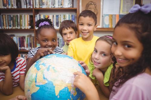 Children point at a globe.