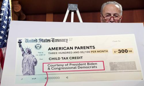 U.S. Senate Majority Leader Chuck Schumer peers out from behind a mock U.S. Treasury check as he holds a press conference on the expanded Child Tax Credit payments at the U.S. Capitol in Washington, U.S., July 15, 2021. REUTERS/Kevin Lamarque