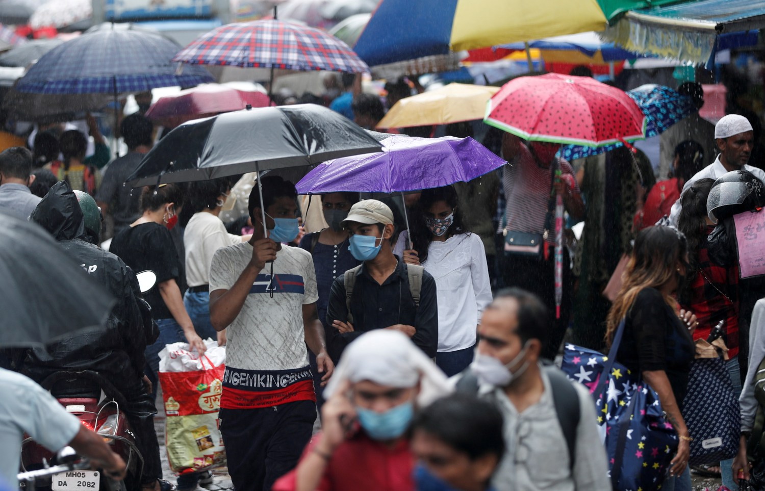 FILE PHOTO: People walk through a crowded market on a rainy day amidst the spread of the coronavirus disease (COVID-19) in Mumbai, India, July 14, 2021. REUTERS/Francis Mascarenhas/File Photo