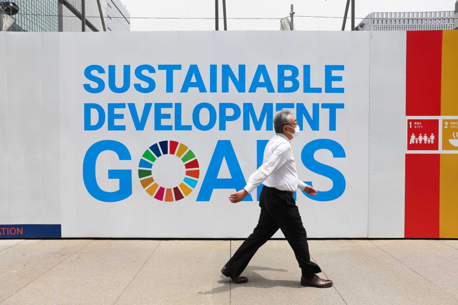 A man wearing a mask as a preventive measure against the spread of covid-19 walks past a sign advertising UN's 'Sustainable development goals' in Ginza.The State of Emergency in Tokyo will last until end of June 2021. (Photo by Stanislav Kogiku / SOPA Images/Sipa USA)No Use Germany.