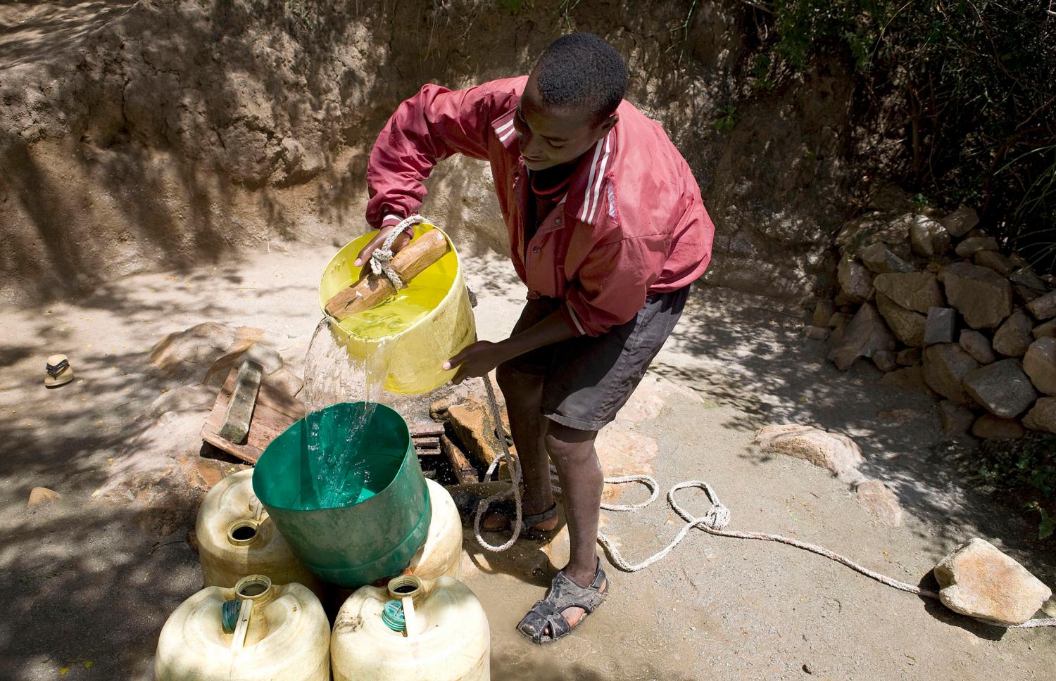A boy collects water from a shallow well on the Kenyan side of Moyale, June 11, 2009. Prolonged drought, lack of water and limited pasture have led to conflict between the Somali and Borena ethnic groups in southern Ethiopia ? that left hundreds of people dead in February this year. The International Federation of Red Cross and Red Crescent Societies (IFRC) says it needs some 100 million Swiss francs to prevent conflict, famine and epidemics as well as restore the livelihoods of 2.5 million people in the Horn of Africa. Picture taken June 11, 2009. REUTERS/Irada Humbatova (KENYA SOCIETY CONFLICT HEALTH)