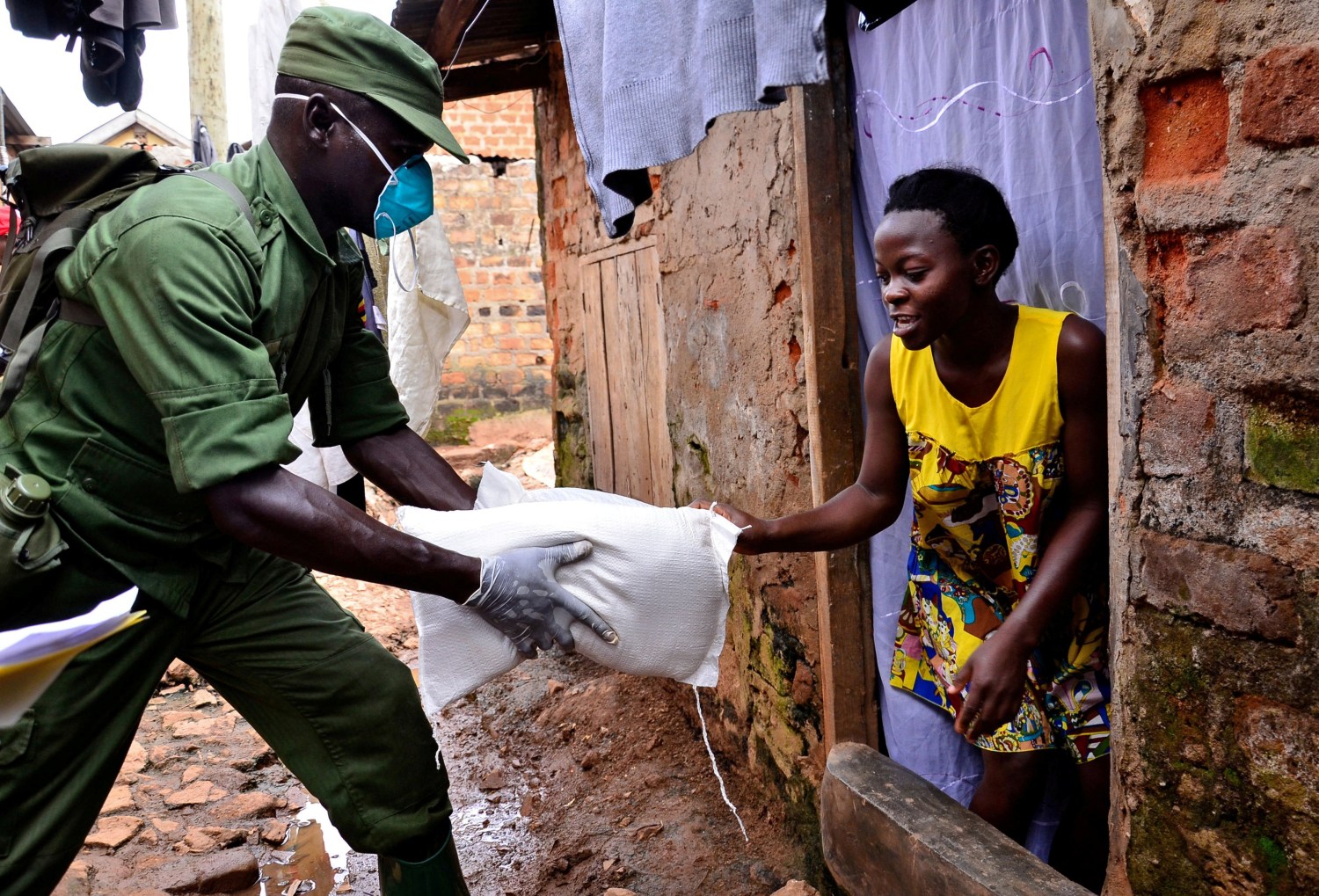 FILE PHOTO: A civilian receives relief food during a government distribution exercise to civilians affected by the lockdown, as part of measures to prevent the potential spread of coronavirus disease (COVID-19), in Kampala, Uganda April 4, 2020. REUTERS/Abubaker Lubowa/File Photo