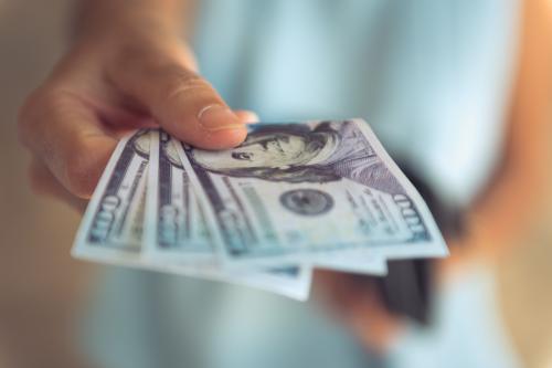 Female hands counting US Dollar bills or paying in cash.