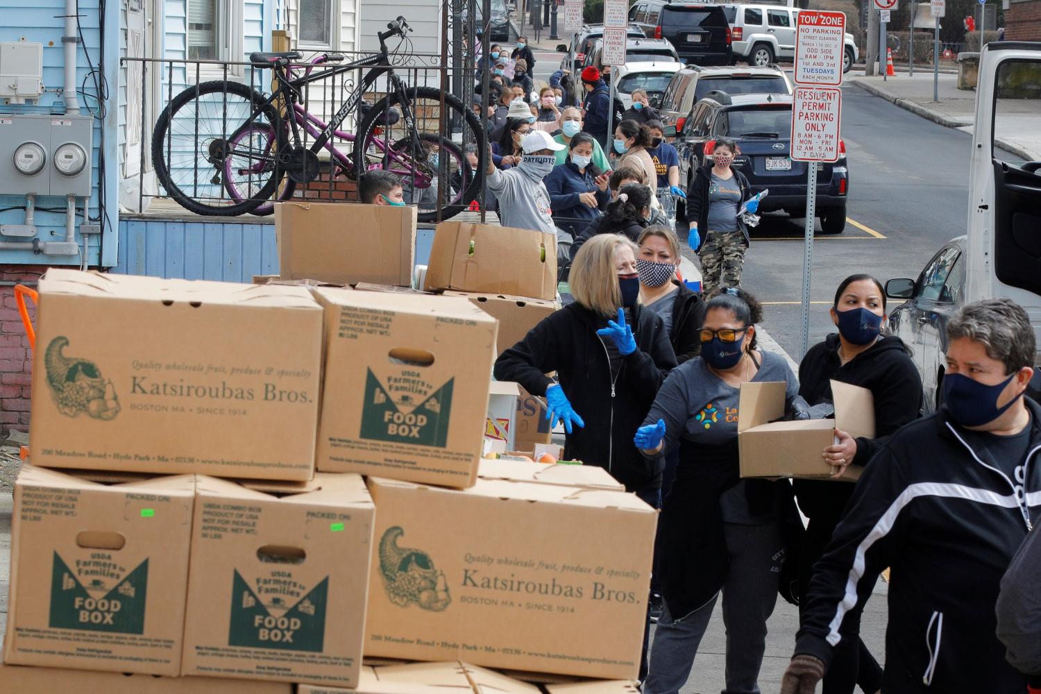 Residents wait in line to pick up free groceries at the food pantry at La Colaborativa amid the coronavirus disease (COVID-19) pandemic in hard hit in Chelsea, Massachusetts, U.S., March 25, 2021.  REUTERS/Brian Snyder