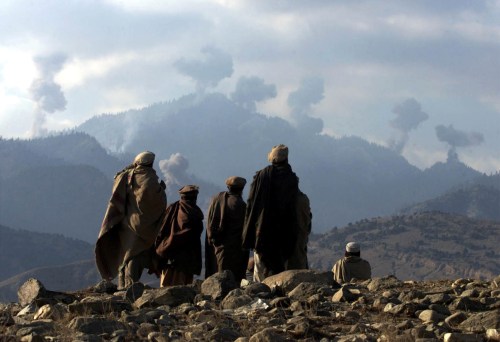 FILE PHOTO: Anti-Taliban Afghan fighters watch several explosions from U.S. bombings in the Tora Bora mountains in Afghanistan in the hunt for al Qaeda fighters, December 16, 2001./File Photo