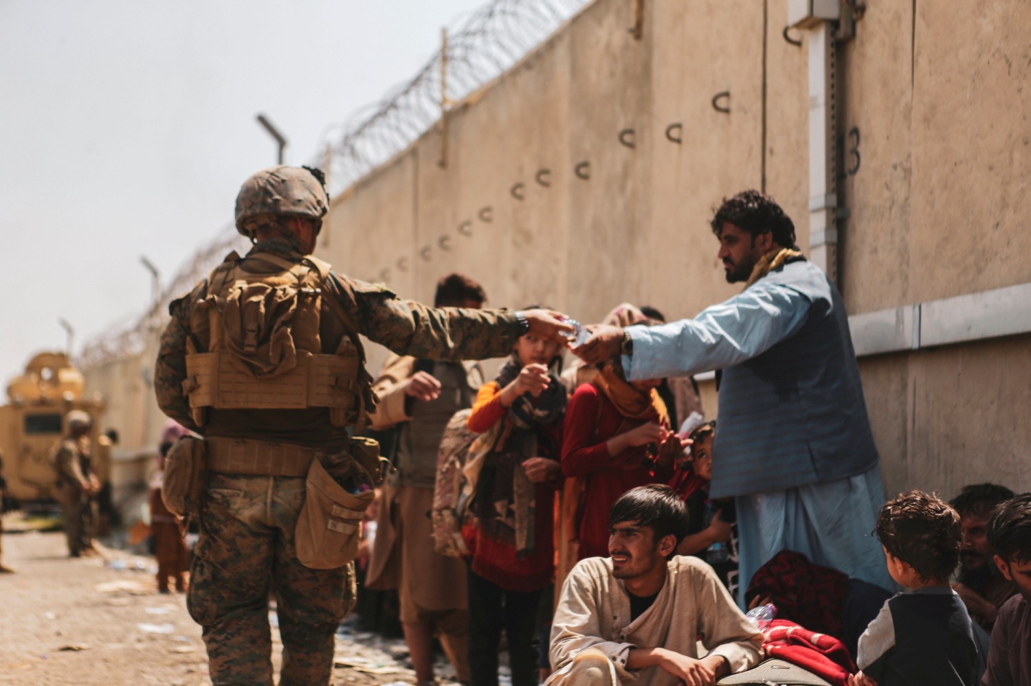 FILE PHOTO: A U.S. Marine passes out water to evacuees during an evacuation at Hamid Karzai International Airport, Kabul, Afghanistan, August 22, 2021. Picture taken August 22, 2021.  U.S. Marine Corps/Sgt. Isaiah Campbell/Handout via REUTERS THIS IMAGE HAS BEEN SUPPLIED BY A THIRD PARTY./File Photo
