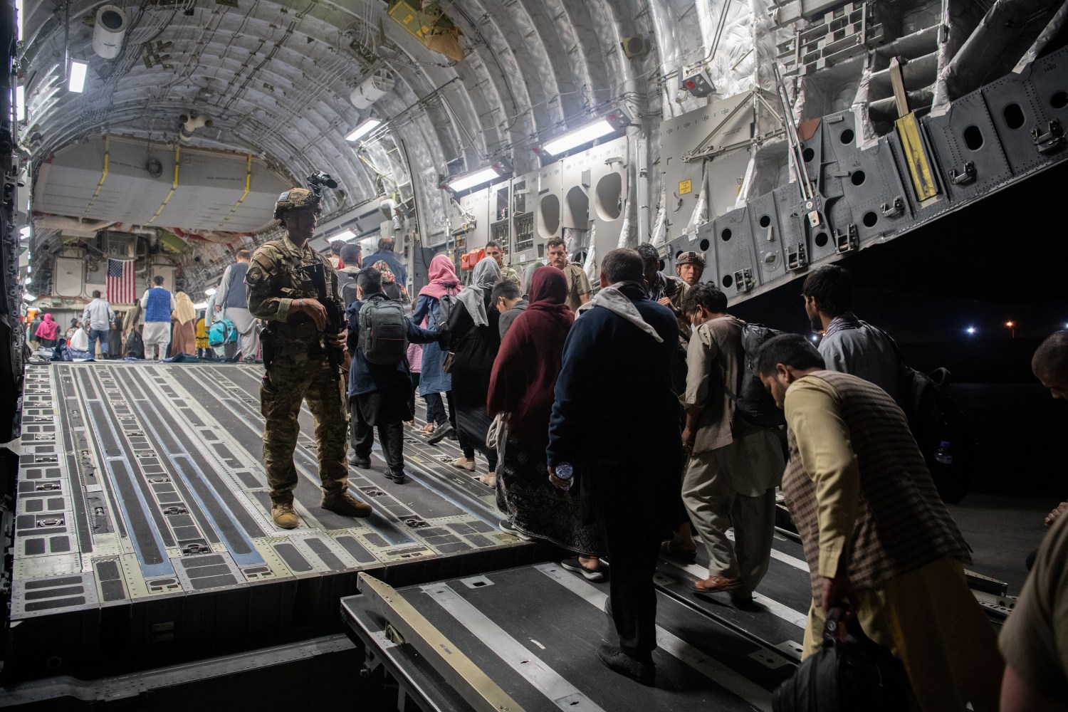 Afghans board a U.S. Air Force C-17 Globemaster III transport plane during an evacuation at Hamid Karzai International Airport, Afghanistan, August 22, 2021. U.S. Air Force/Handout via REUTERS