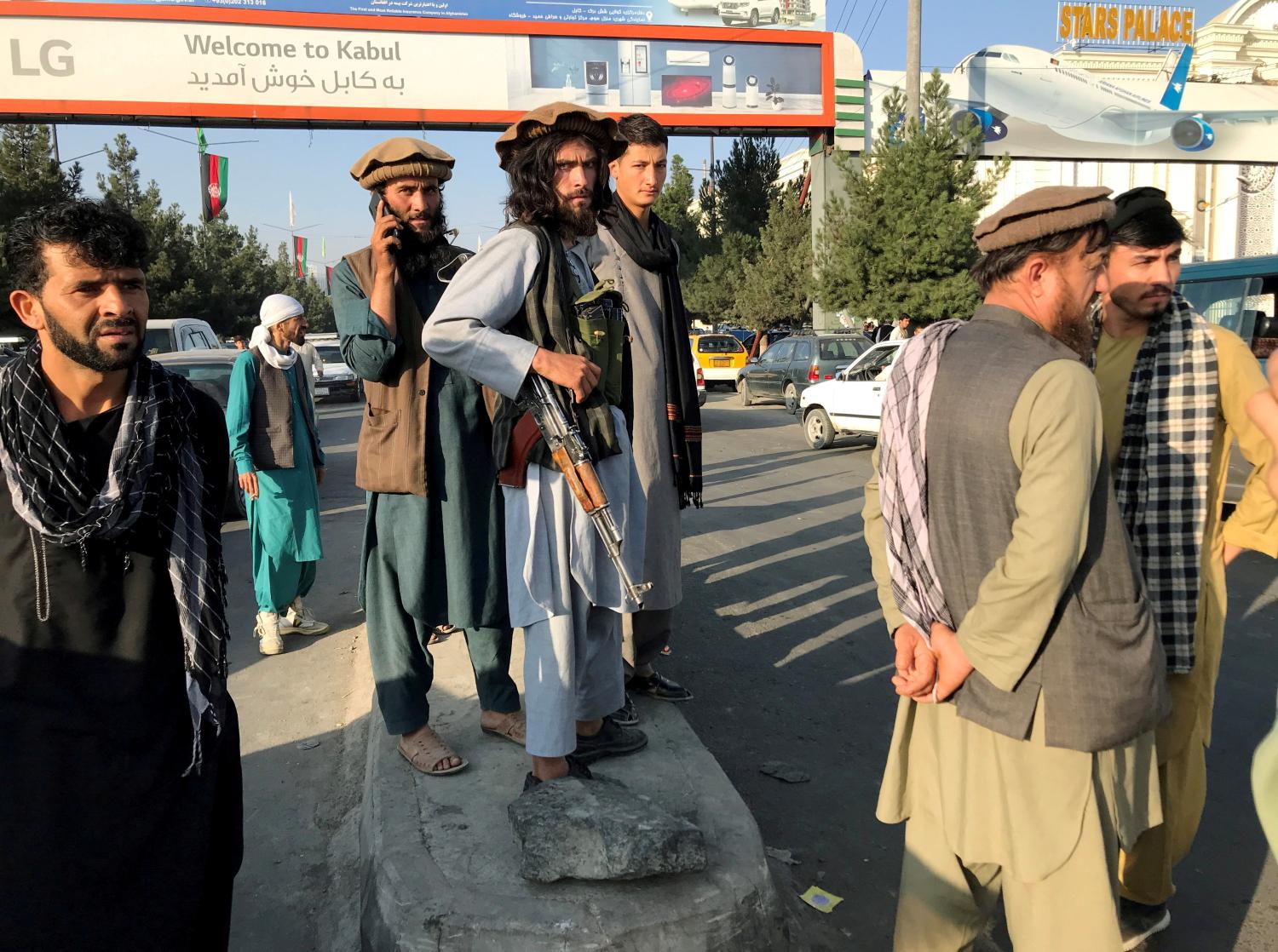 A member of Taliban (C) stands outside Hamid Karzai International Airport in Kabul, Afghanistan, August 16, 2021. REUTERS/Stringer