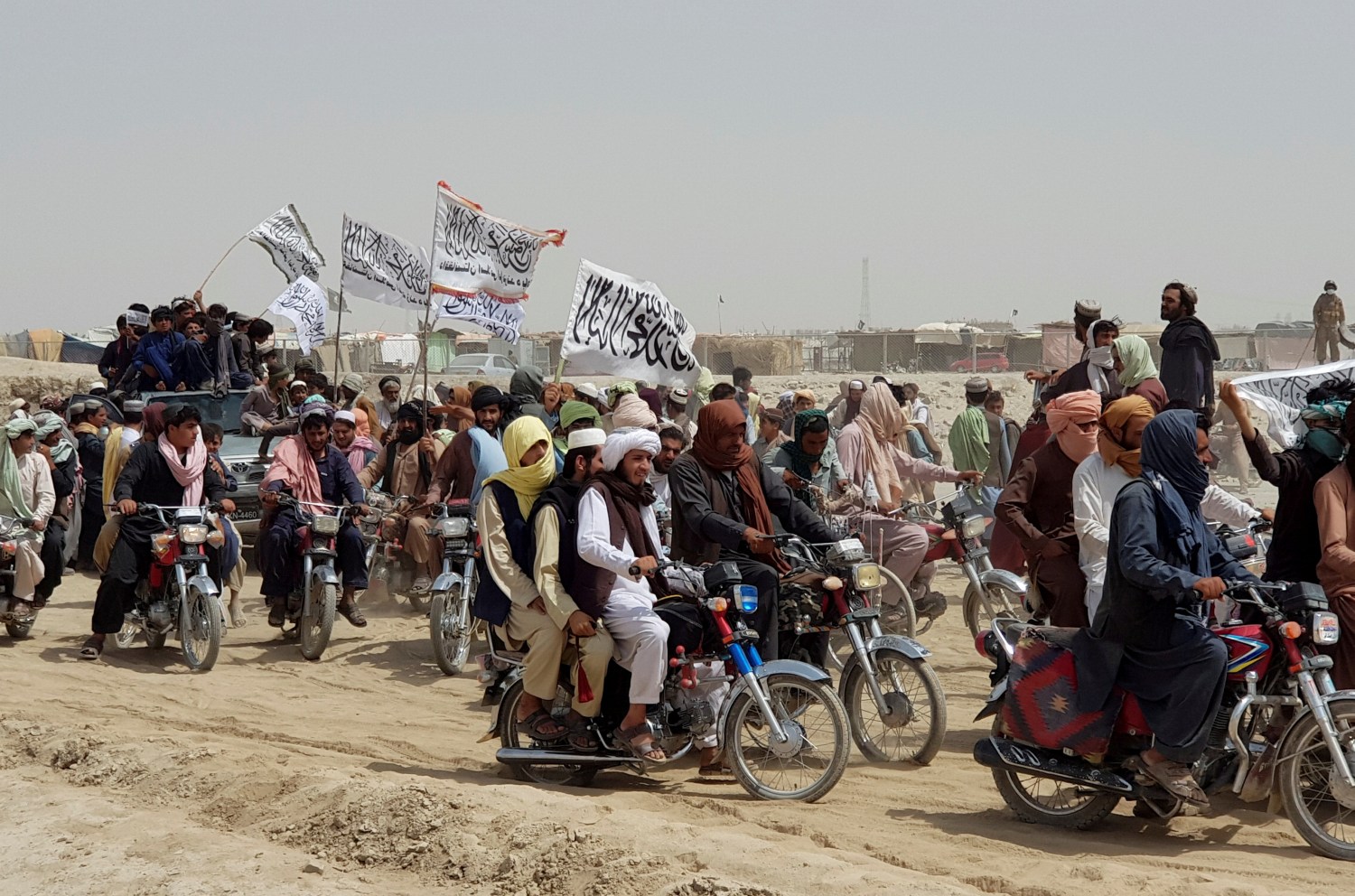 People on vehicles, holding Taliban flags, gather near the Friendship Gate crossing point in the Pakistan-Afghanistan border town of Chaman, Pakistan July 14, 2021. Picture taken July 14, 2021. REUTERS/Abdul Khaliq Achakzai