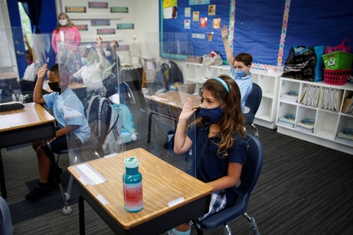 A student wearing a protective mask, attends class on the first day of school, amid the coronavirus disease (COVID-19) pandemic, at St. Lawrence Catholic School in North Miami Beach, Florida, U.S. August 18, 2021. REUTERS/Marco Bello