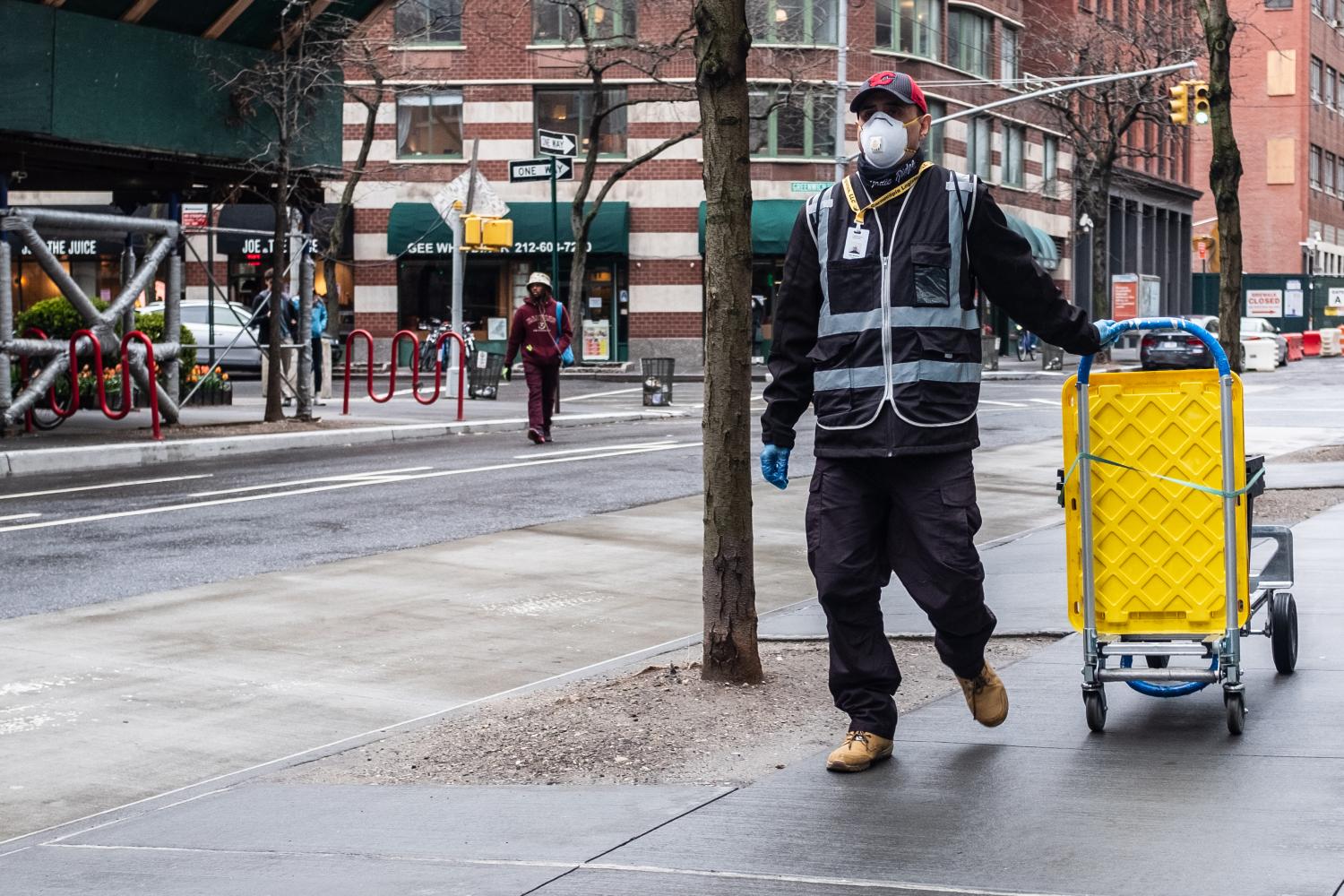 An essential delivery worker wearing personal protective equipment in Tribeca, New York during the COVID-19 pandemic.
