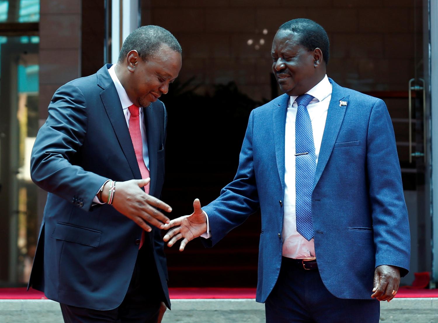 Kenya's President Uhuru Kenyatta (L) greets opposition leader Raila Odinga of the National Super Alliance (NASA) coalition after addressing a news conference at the Harambee house office in Nairobi, Kenya March 9, 2018. REUTERS/Thomas Mukoya