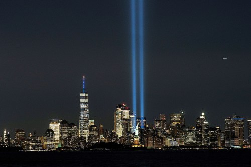 The Statue of Liberty and One World Trade Center are seen as the Tribute in Light shines in downtown Manhattan.