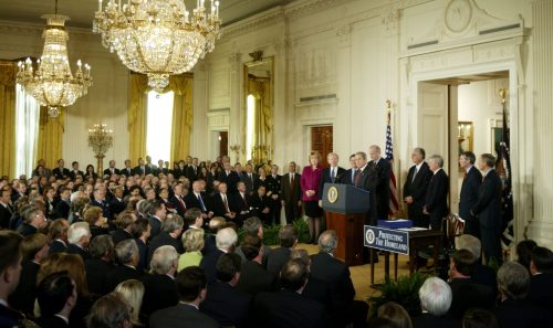 Surrounded by members of Congress, U.S. President Bush George W. Bush(at podium) prepares to sign the Homeland Security Act November 25,2002 creating a vast Department of Homeland Security to preventterrorist attacks on the United States, setting in motion the biggestgovernment reorganization in half a century that could take years tocomplete. "The continuing threat of terrorism, the threat of massmurder on our own soil will be met by a unified, effective response,"Bush said at the White House signing ceremony. REUTERS/Win McNameeWM/GAC