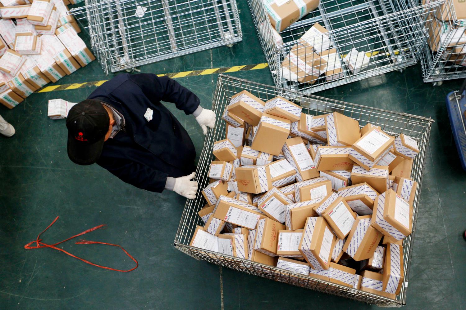 A Chinese worker carts parcels, most of which are from online shopping, at the warehouse of an e-commerce company.