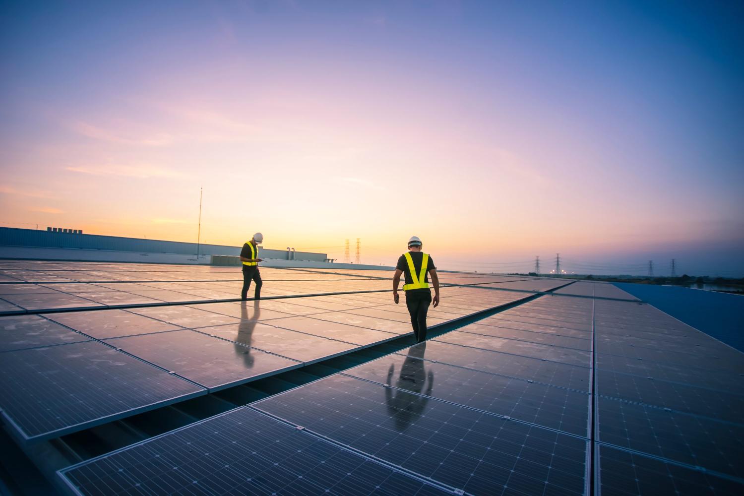 Workers examining solar panels.