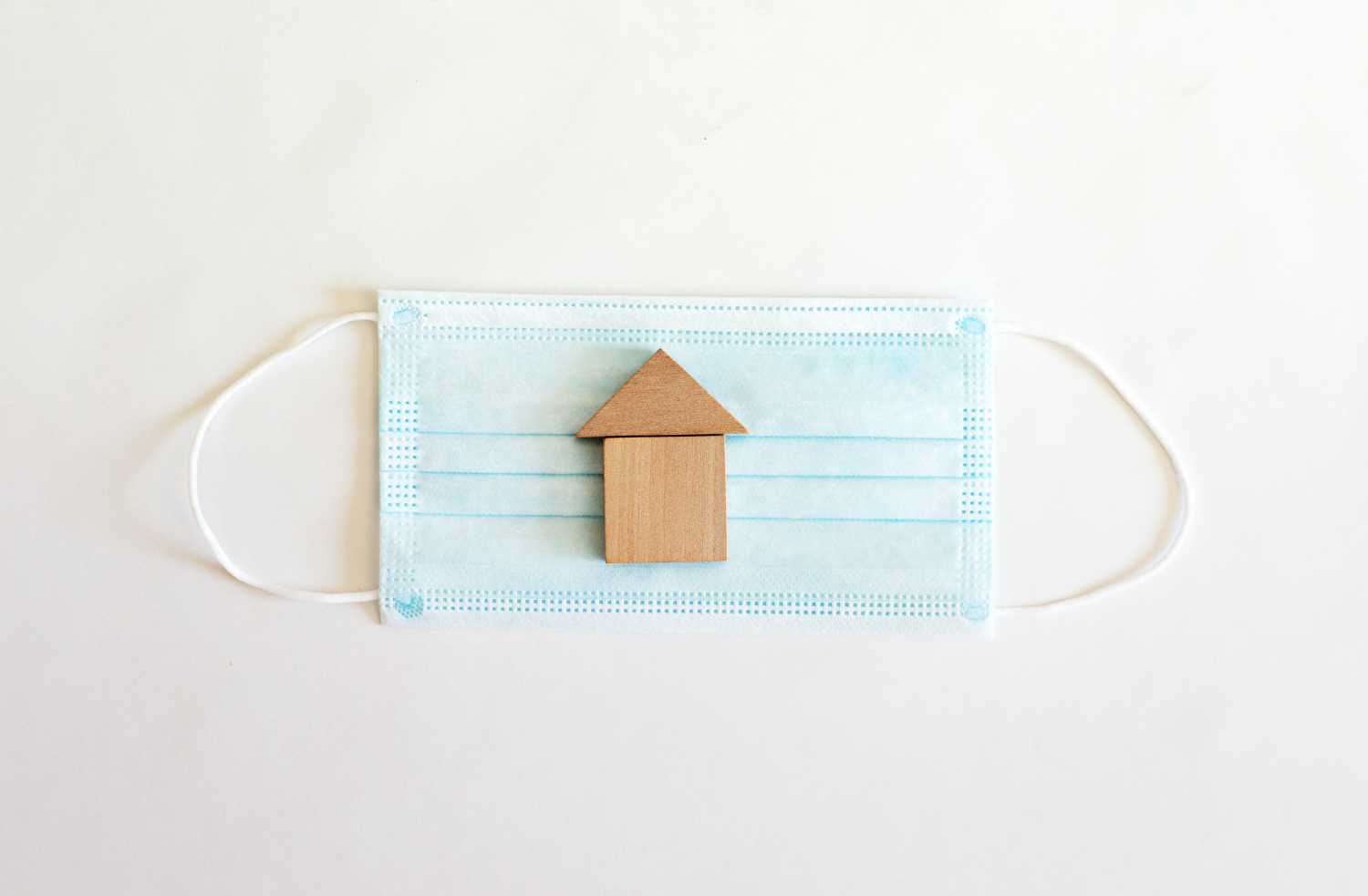 Surgical mask with a small wooden house on it.