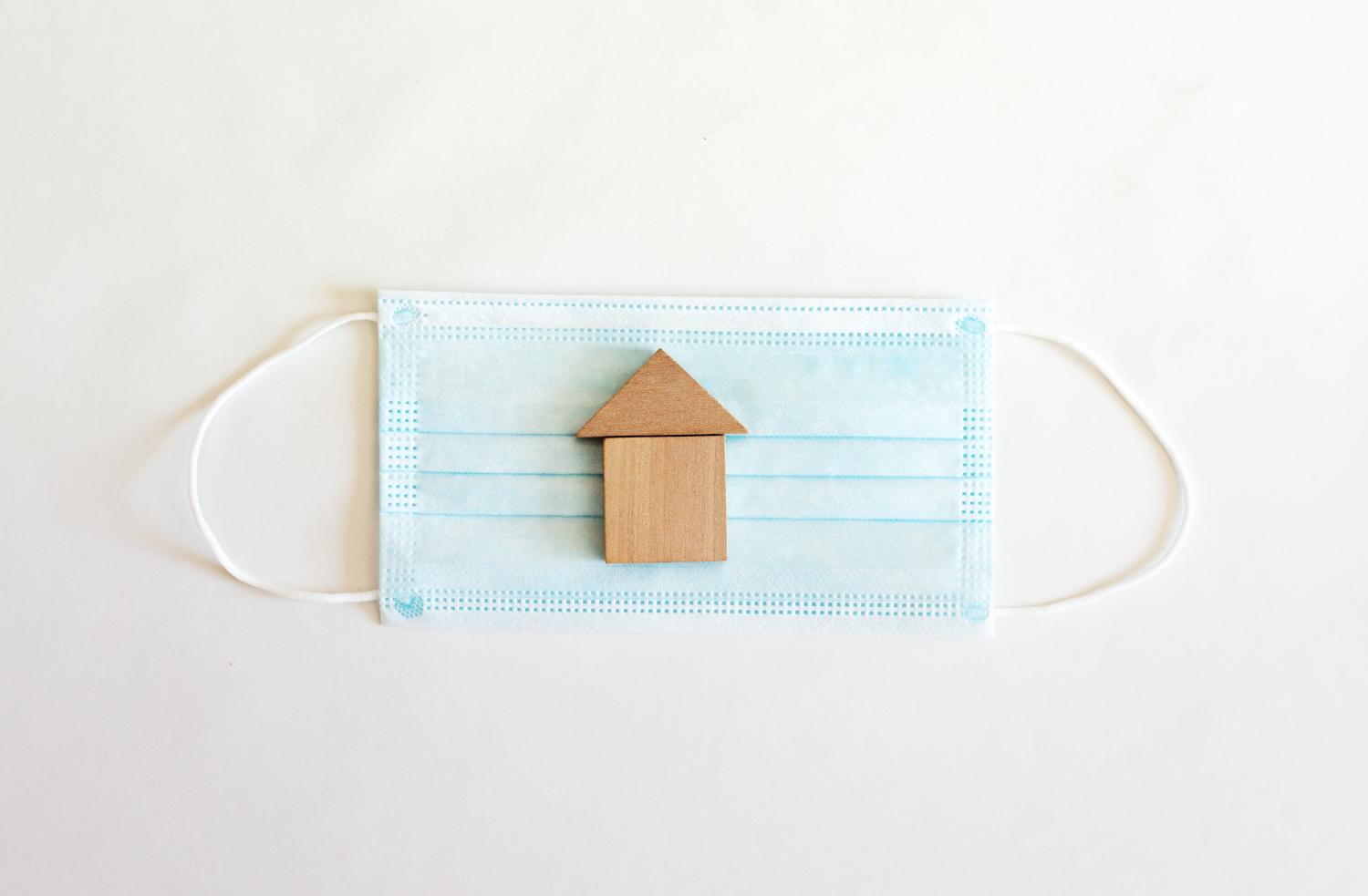 Surgical mask with a small wooden house on it.