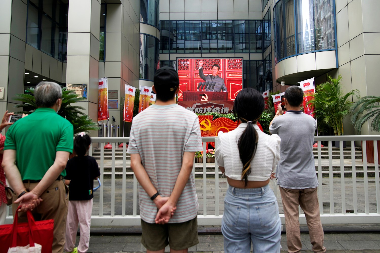 People watch a giant screen broadcasting Chinese President Xi Jinping's speech at a celebration marking the 100th founding anniversary of the Communist Party of China, in Shanghai July 1, 2021. REUTERS/Aly Song