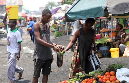FILE PHOTO: A Congolese man buys groceries at an open air market, amid concerns about the spread of coronavirus disease (COVID-19) in Kinshasa, Democratic Republic of Congo, March 28, 2020. REUTERS/Kenny Katombe/File Photo