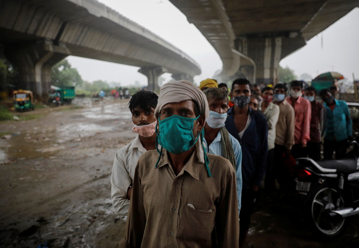 People wait to receive a dose of COVAXIN coronavirus disease (COVID-19) vaccine manufactured by Bharat Biotech, during a vaccination drive organised by SEEDS, an NGO which normally specialise in providing relief after floods and other natural disasters, at an under-construction flyover in New Delhi, India, August 31, 2021. REUTERS/Adnan Abidi