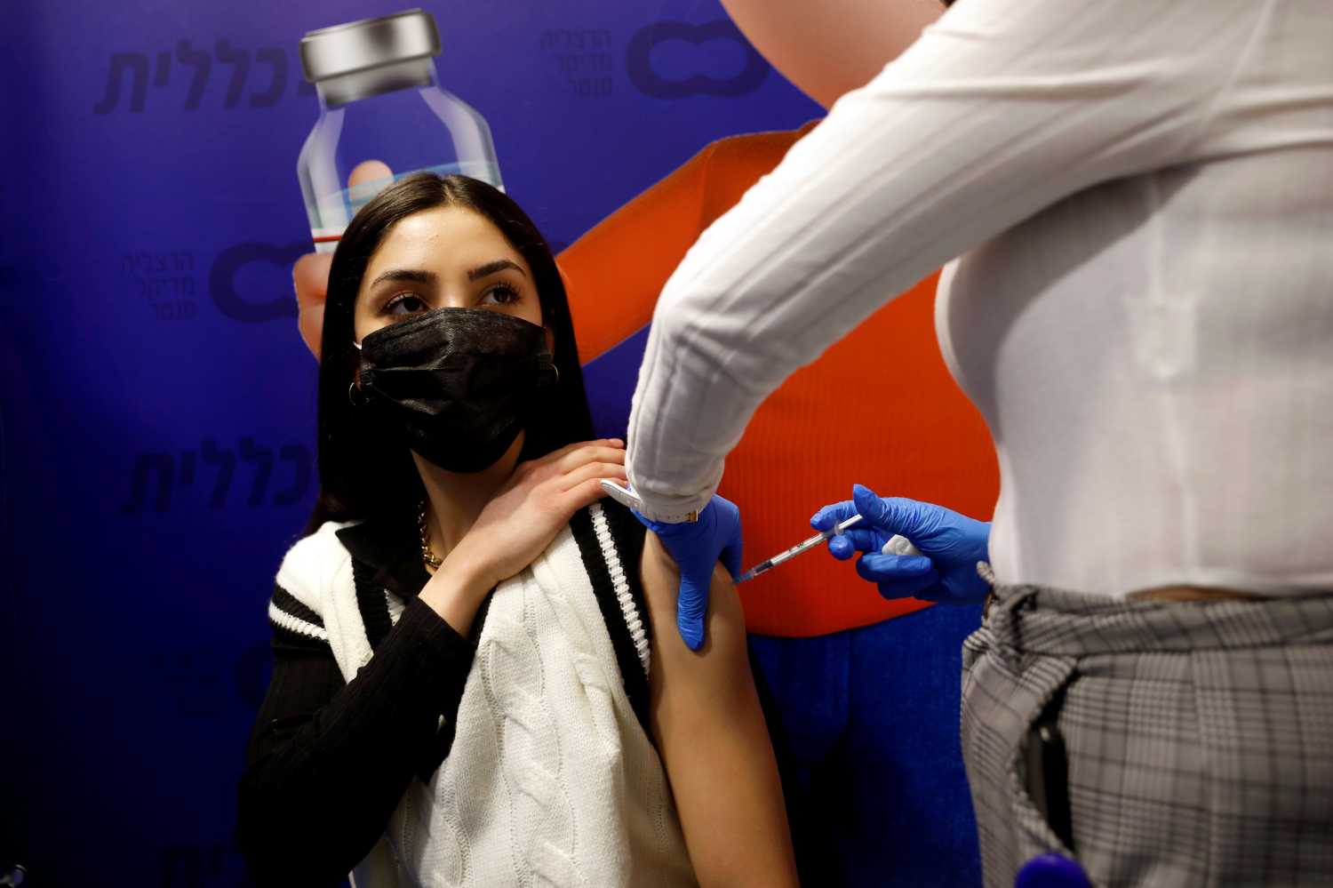 FILE PHOTO: A woman receives a vaccination against the coronavirus disease (COVID-19) at a temporary Clalit healthcare maintenance organisation (HMO) centre, in Herzliya, Israel February 3, 2021. REUTERS/Amir Cohen/File Photo