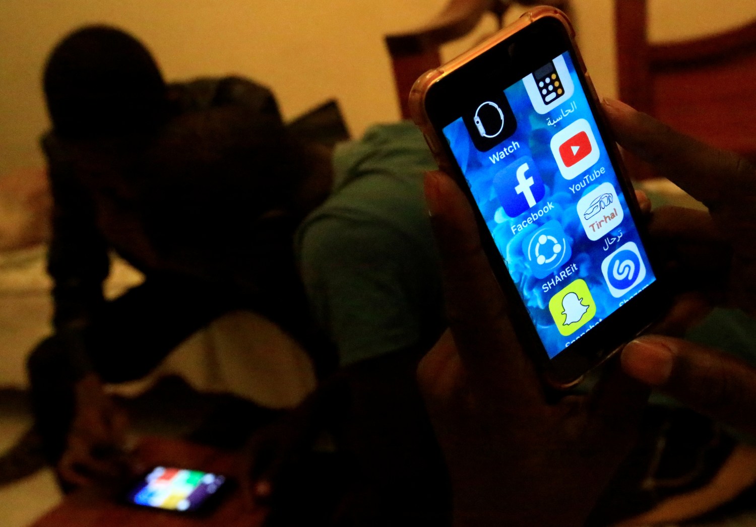 A Sudanese man holds his phone with restricted internet access social media platforms, in Khartoum, Sudan January 1, 2019. Picture taken January 1, 2019. REUTERS/Mohamed Nureldin Abdallah