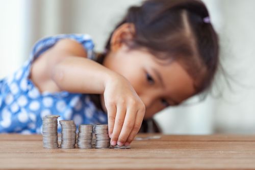 Young girl lining up stacks of coins