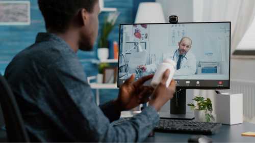 Black man at home seeking medical help from doctor via online intenet telehealth consultation with family doctor.