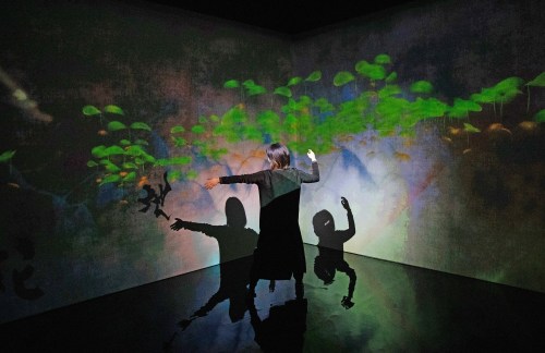A woman interacts with a digital art installation exploring the relationship between humans and artificial intelligence.