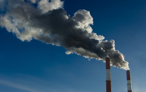 Two factory stacks emitting pollution into the air