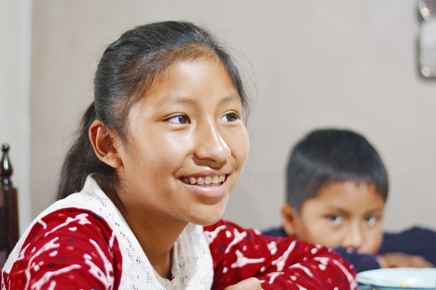 A Mayan girl smiles.