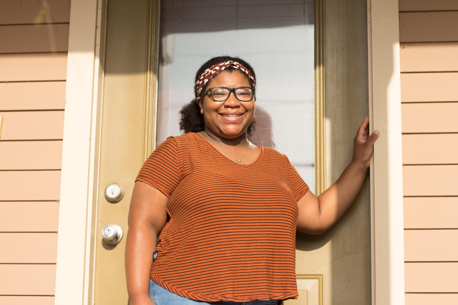 A happy Cambray Hall stands at the doorway of her newly purchased Crescent City Community Land Trust single family home located in the Lower 9th Ward of New Orleans in July 2020.