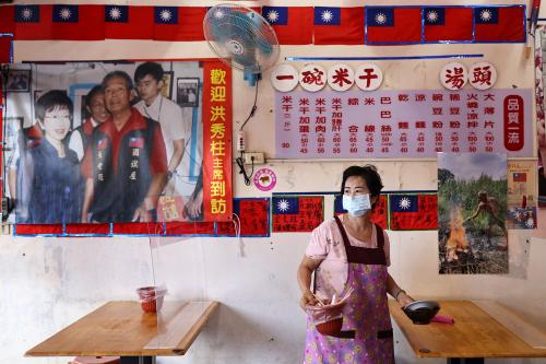 Staff cleans the table of a restaurant that is decorated with Taiwan flags in Taoyuan, Taiwan, October 8, 2021. REUTERS/Ann Wang