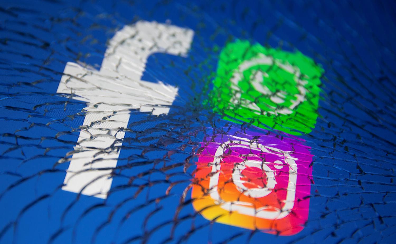 Facebook, Whatsapp and Instagram logos are displayed through broken glass in this illustration taken October 4, 2021. REUTERS/Dado Ruvic/Illustration