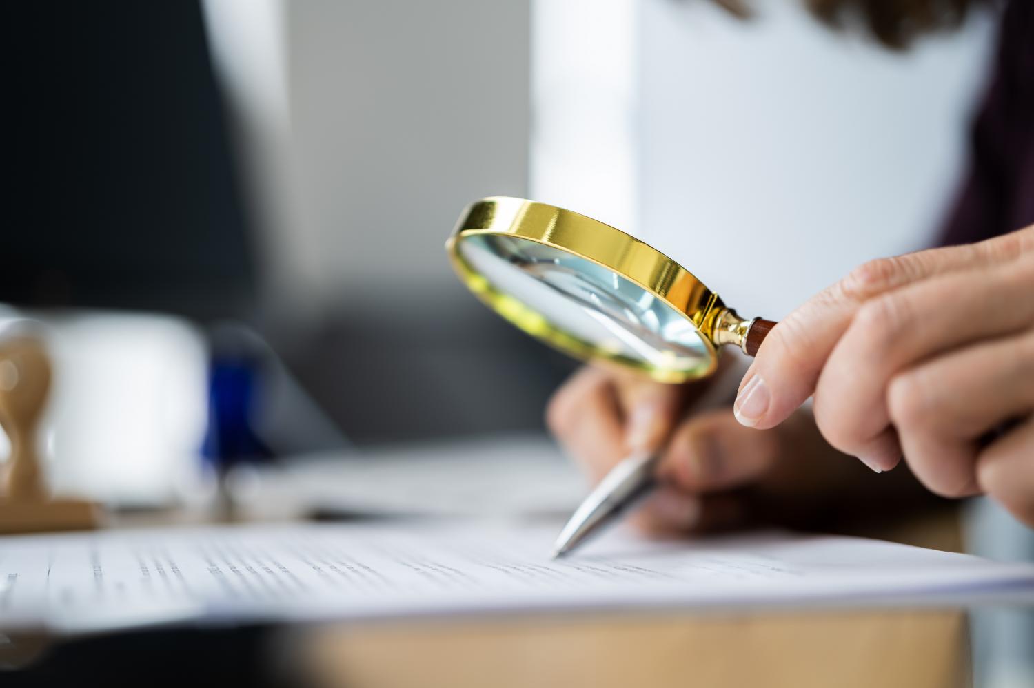 Auditor Doing Tax Fraud Investigation Using Magnifying Glass